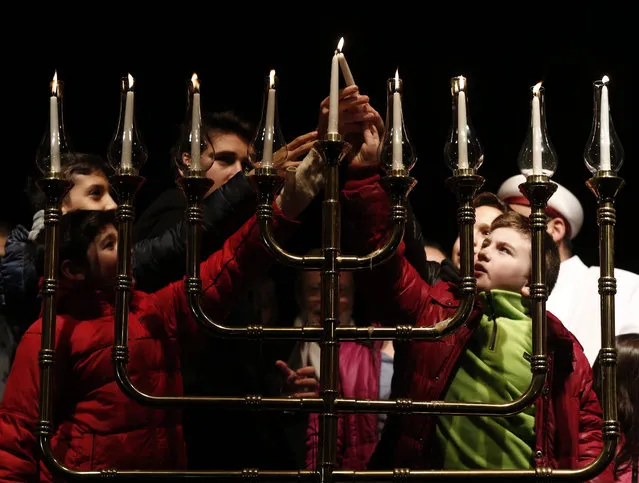 Turkish-Jewish children light a Menorah to celebrate the ongoing Jewish festival of Hanukkah in Istanbul, Turkey, 13 December 2015. Hanukkah, the Jewish Festival of Lights, celebrates the revolt of the Maccabees in 165 BCE against the Syrian-Greek forces that had been occupying the Jewish temple in Jerusalem. (Photo by Sedat Suna/EPA)