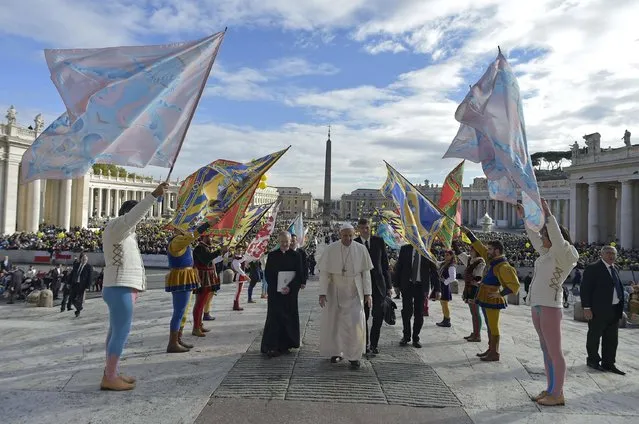 This handout photo taken on November 12, 2016 and released by the Vatican press office, the Osservatore Romano, shows Pope Francis (C) walking upon arrival to lead his Jubilee audience in St. Peter's Square at the Vatican. (Photo by Osservatore Romano/AFP Photo)