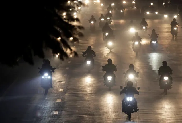 People commute on motorbikes during a smoggy evening as the air quality of Kathmandu reaches hazardous levels, Nepal on January 4, 2021. (Photo by Navesh Chitrakar/Reuters)