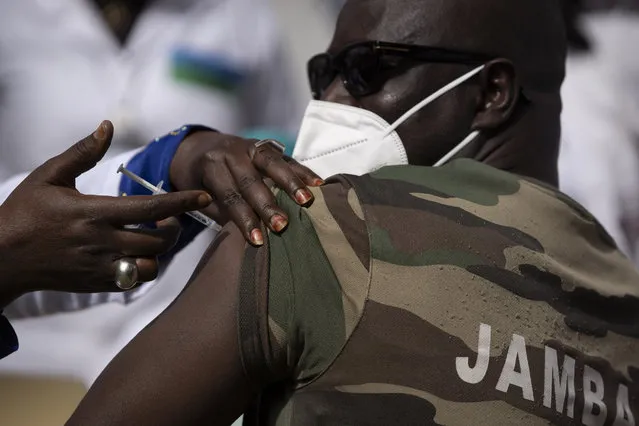 A member of the Army Forces receives a dose of the China's Sinopharm vaccine during the start of the vaccination campaign against the COVID-19 at the Health Ministry in Dakar, Senegal, Tuesday, February 23, 2021. The country is also expecting nearly 1.3 million vaccine doses through the COVAX initiative. (Photo by Leo Correa/AP Photo)