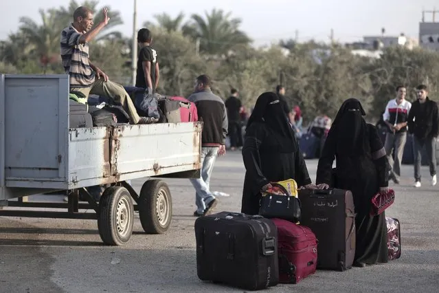 Palestinians wait with their luggage to cross the border into Egypt, at the Rafah border crossing in the southern Gaza Strip, Saturday, October 15, 2016. (Photo by Khalil Hamra/AP Photo)