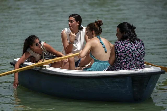 A group of women relax on a rowing boat in the Retiro park lake in Madrid, Spain, Monday, July 17, 2023. Spain’s Aemet weather agency said the heat wave this week “will affect a large part of the countries bordering the Mediterranean“ with temperatures in some southern areas of Spain exceeding 42 C (107 F). (Photo by Manu Fernandez/AP Photo)