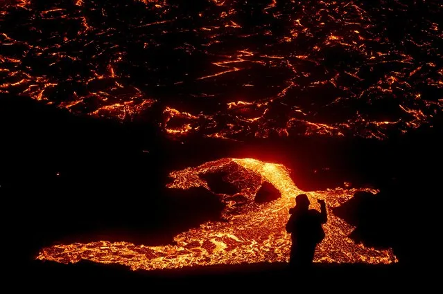 Lava flows from a volcano in Reykjanes Peninsula, Iceland on March 21, 2021. The volcano erupted near Iceland's capital Reykjavik on Friday, shooting lava high into the night sky after thousands of small earthquakes in recent weeks. (Photo by Sigtryggur Johannsson/Reuters)