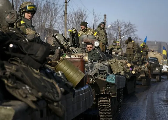 Members of the Ukrainian armed forces ride on armoured personnel carriers (APC) near Debaltseve, eastern Ukraine, February 12, 2015. (Photo by Gleb Garanich/Reuters)