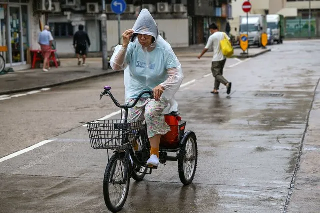 A woman rides her tricycle in rain brought by Super Typhoon Saola on Lantau island in Hong Kong on September 1, 2023. Super Typhoon Saola threatened southern China on September 1 with some of the strongest winds the region has endured, forcing the megacities of Hong Kong and Shenzhen to effectively shut down. (Photo by Peter Parks/AFP Photo)