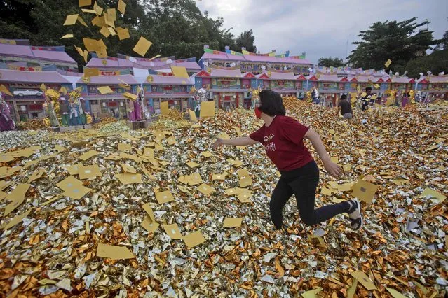 An ethnic Chinese woman throws imitation money known as “hell money” to be burned as offerings, during the Hungry Ghost Festival in Medan, North Sumatra, Indonesia, Wednesday, August 30, 2023. The festival is celebrated during the seventh month of the Chinese lunar calendar, when prayers are offered to the dead and offerings of food and paper-made models of items such as televisions and cars are burned to appease wandering spirits as it is believed that the gates of hell are opened during the month and the souls of dead ancestors return to visit their relatives. (Photo by Binsar Bakkara/AP Photo)