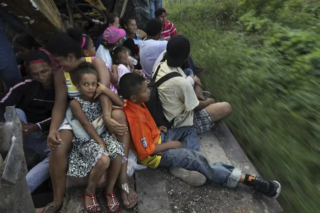 Central American migrants, part of the caravan hoping to reach the U.S. border, travel on a truck in Loma Bonita, Oaxaca state, Mexico, Saturday, November 3, 2018. (Photo by Rodrigo Abd/AP Photo)