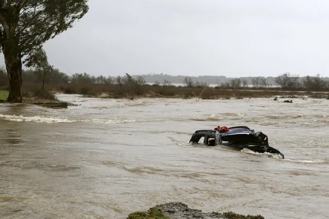 The wreckage of a car sits in flood waters in Biguglia on the French Mediterranean island of Corsica on March 17, 2015. Rescue teams are still looking for the driver. (Photo by Pascal Pochard-Casabianca/AFP Photo)