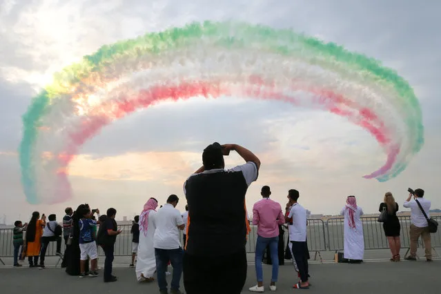 People view a performance by the Frecce Tricolori (313° Gruppo Addestramento Acrobatico) aerobatic demonstration team of the Italian Aeronautica Militare during the 2018 Bahrain International Air Show at the Sakhir air base in Bahrain on November 16, 2018. 33 military delegations from 19 countries and 20 civilian ones from 35 countries take part in the show. (Photo by Sergei Savostyanov/TASS)