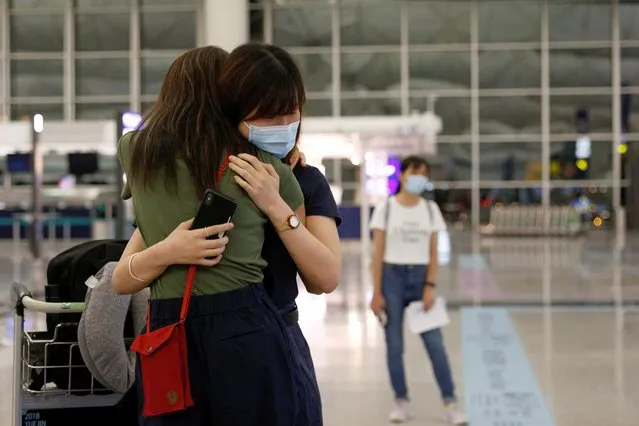 A woman hugs with her friend before departing to United Kingdom at the Hong Kong International Airport in Hong Kong, China on June 30, 2021. (Photo by Tyrone Siu/Reuters)