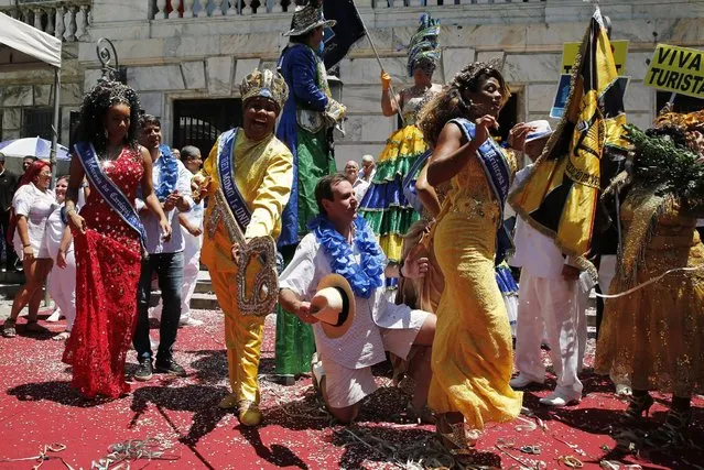 Rio de Janeiro's Mayor Eduardo Paes (C) kneels next to the “Rei Momo”, or Carnival King Wilson Neto (2nd L) as they pose for picture during the handing over of the ceremonial key to the city at the Cidade Palace in Rio de Janeiro, Brazil, February 5, 2016. The event officially kicks off the 2016 carnival week in Rio. (Photo by Sergio Moraes/Reuters)