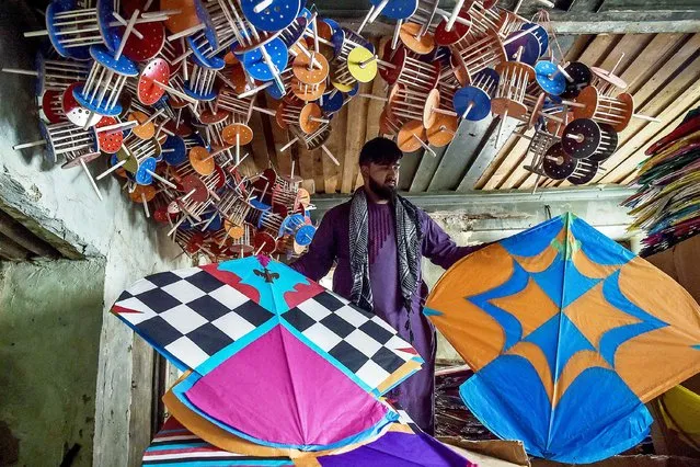 In this photo taken on June 9, 2021, a kite vendor shows his merchandise inside a warehouse in Shor Bazaar in the old quarters of Kabul. The Taliban outlawed dozens of seemingly innocuous activities and pastimes in Afghanistan during their 1996-2001 rule – including kite flying, TV soap operas, pigeon racing, fancy haircuts, and even playing music. These have made a comeback in the years since, but fears are growing they will be banned again if the hardline Islamists return to power. (Photo by Wakil Kohsar/AFP Photo)