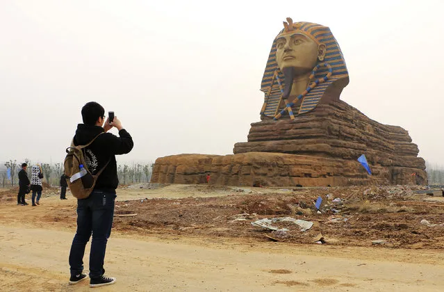 A man takes pictures of a full scale replica of the sphinx, which is part of an unfinished movie and animation tourism theme park, in Chuzhou, Anhui province, China, March 3, 2015. (Photo by Reuters/Stringer)