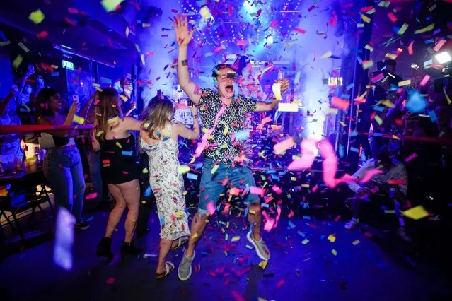 A man jumps on the dance floor shortly after the reopening, at The Piano Works in Farringdon, in London, Monday, July 19, 2021. The country's nightclubs are reopening for the first time in 17 months as almost all coronavirus rules are set to be scrapped. (Photo by Alberto Pezzali/AP Photo)
