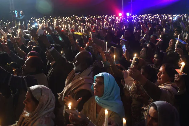 Pakistani Christians attend the candle light Carol service during the Christmas celebration in Lahore on December 19, 2018. (Photo by Arif Ali/AFP Photo)