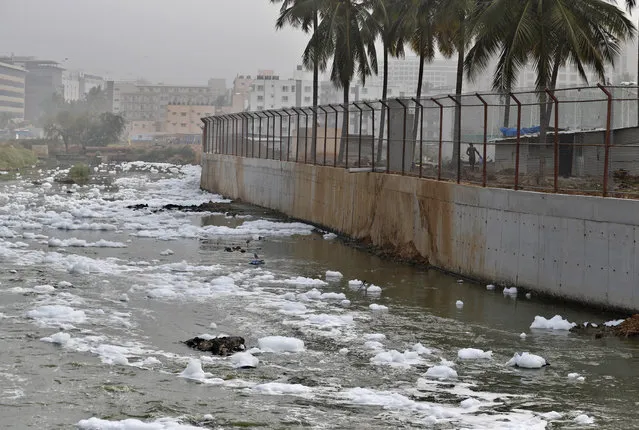 In this Monday, December 10, 2018 photo toxic froth from industrial pollution floats on Bellundur Lake in Bangalore, India. As politicians haggle at a U.N. climate conference in Poland over ways to limit global warming, the industries and machines powering our modern world keep spewing their pollution into the air and water. The fossil fuels extracted from beneath the earth's crust – coal, oil and gas – are transformed into the carbon dioxide that is now heating the earth faster than scientists had expected even a few years ago. (Photo by Aijaz Rahi/AP Photo)