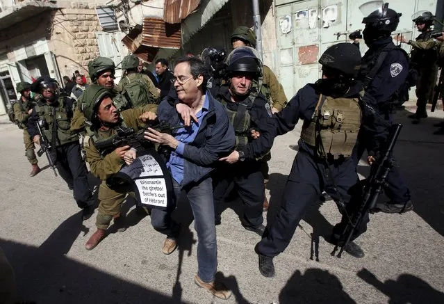 Israeli soldiers and border policemen detain an Israeli peace activist during a demonstration against the closure of Shuhada street to Palestinians, in the West Bank city of Hebron February 20, 2016. (Photo by Mussa Qawasma/Reuters)