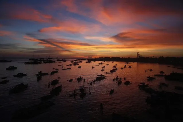 A flotilla of bancas (locally made boats) carrying evacuees displaced from their homes due to fighting between government soldiers and Muslim rebels from the Moro National Liberation Front (MNLF), is seen during sunset at a wharf in Zamboanga city, southern Philippines September 14, 2013. (Photo by Erik De Castro/Reuters)