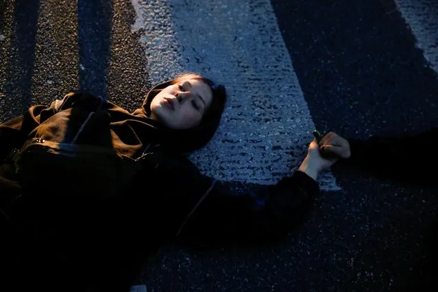 People lie on the ground during a protest against the state of emergency declared at the Polish border with Belarus, in front of the Parliament in Warsaw, Poland on September 6, 2021. (Photo by Kacper Pempel/Reuters)