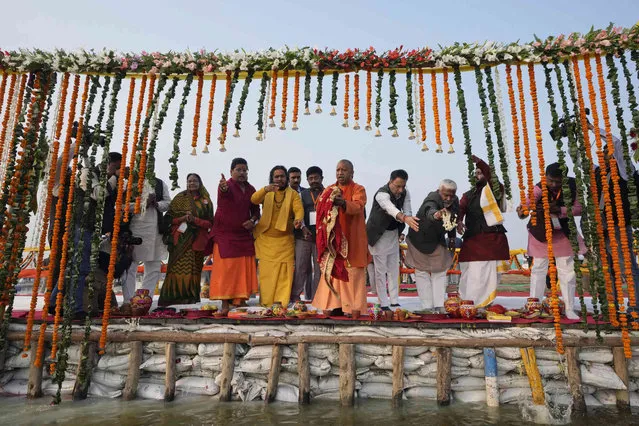 Chief Minister of Uttar Pradesh state, Yogi Adityanath, center, in saffron robe, participates in a ritual prayer at Sangam, the confluence of the rivers Ganges, Yamuna and the mythical Saraswati, ahead of the annual Hindu religious festival “Magh Mela” at Prayagraj, India, Wednesday, December 27, 2023. Thousands of people take holy dips at the confluence of the rivers Ganges, Yamuna and the mythical Saraswati during the month-long fair that begins later this month. (Photo by Rajesh Kumar Singh/AP Photo)