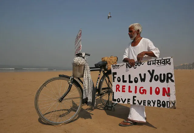 Krishna Das, 58, an Indian who according to local media has spent at least 10 years trying to spread messages for peace and harmony by placing placards on beaches, packs his placards on a beach in Mumbai, February 11, 2019. (Photo by Francis Mascarenhas/Reuters)