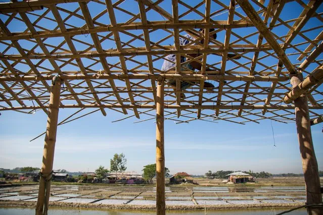  A man builds a new house in Ali Akbar Dale. The extreme weather events that have had such an impact on communities here are predicted to increase with climate change. (Photo by Noor Alam/Majority World)