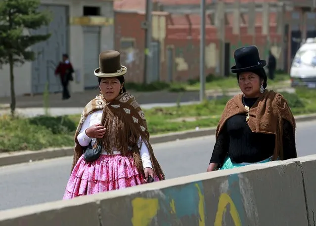 Aymara women walk on a highway as the city celebrates the 31st anniversary of its foundation in El Alto, on the outskirts of La Paz March 6, 2016. (Photo by David Mercado/Reuters)