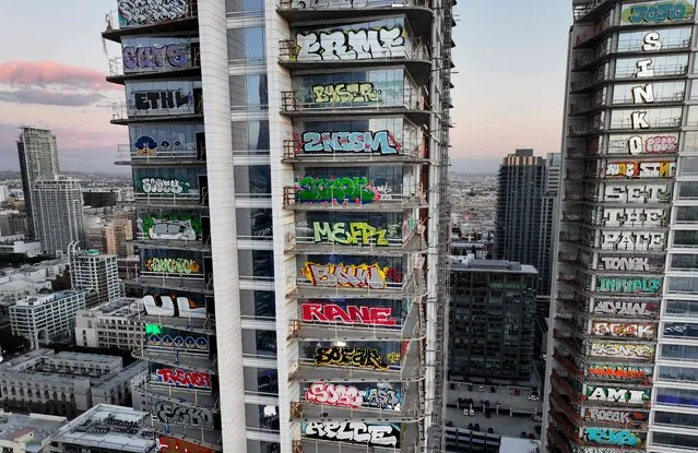 An aerial view of graffiti spray painted by taggers on at least 27 stories of an unfinished skyscraper development located downtown on February 2, 2024 in Los Angeles, California. Construction of the $1 billion Oceanwide Plaza luxury real estate development stalled in 2019 after a China-based developer ran out of funding leaving the three-tower project uncompleted. The project is located across the street from the Crypto.com Arena where the Grammy Awards will be held on February 4. (Photo by Mario Tama/Getty Images/AFP Photo)