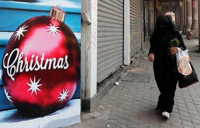 An Egyptian woman wearing a full veil (niqab) walks in front of a Christmas decorations shop in Cairo, Egypt December 3, 2018. (Photo by Amr Abdallah Dalsh/Reuters)