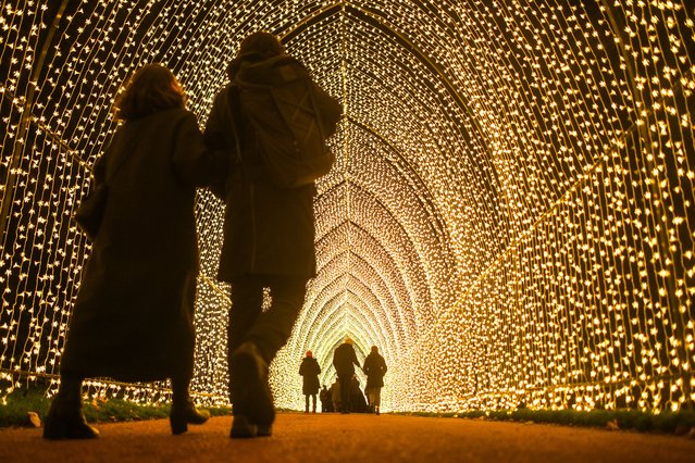 People are seen walking through a tunnel of lights at the Royal Botanic Gardens Edinburgh is seen lit up on November 25, 2021 in Edinburgh, Scotland. The 2021 Christmas at the Botanics trail officially opens its doors today (25 November) until 2nd January 2022 unveiling several new magical attractions alongside many festive favourites at the Royal Botanic Garden Edinburgh. (Photo by Peter Summers/Getty Images)