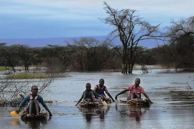 Pupils navigate a swamp on reed-rafts to get to school at Katuit primary in Chesesoi village on the shores of the Kenyan rift valley's Lake Baringo, on March 14, 2014. A few dozen students at the school have been cut-off by the swelling lake that has now risen to reclaim plains from which it had receded more than a decade ago, according to residents, and are now forced to navigate through swamps rife with submerged vegetation, hippo and crocodile to get to their weather-prone classrooms. (Photo by Tony Karumba/AFP Photo)