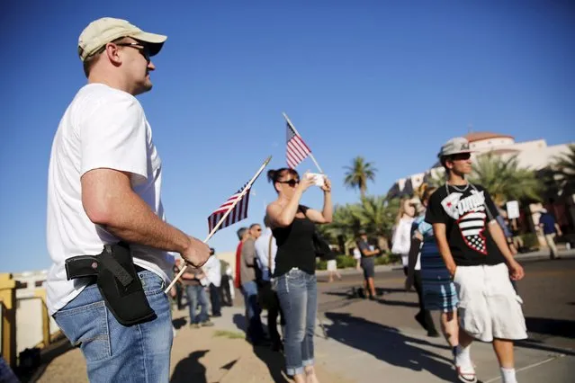 A demonstrator with a hand gun attends a "Freedom of Speech Rally Round II" across the street from the Islamic Community Center in Phoenix, Arizona May 29, 2015.  Arizona police stepped up security near a mosque on Friday ahead of a planned anti-Islam demonstration featuring displays of cartoons of the Prophet Mohammad, weeks after a similar contest in Texas came under attack from two gunmen.  REUTERS/Nancy Wiechec