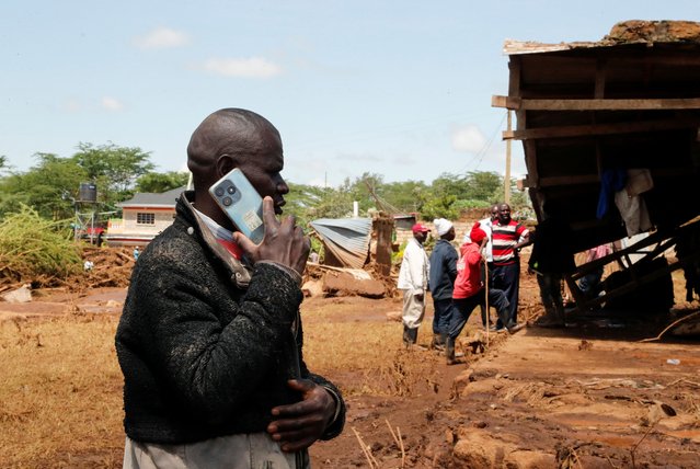 A man talks on a mobile phone as residents search for missing people after heavy flash floods wiped out several homes when a dam burst, following heavy rains in Kamuchiri village of Mai Mahiu, Nakuru County, Kenya on April 29, 2024. (Photo by Thomas Mukoya/Reuters)