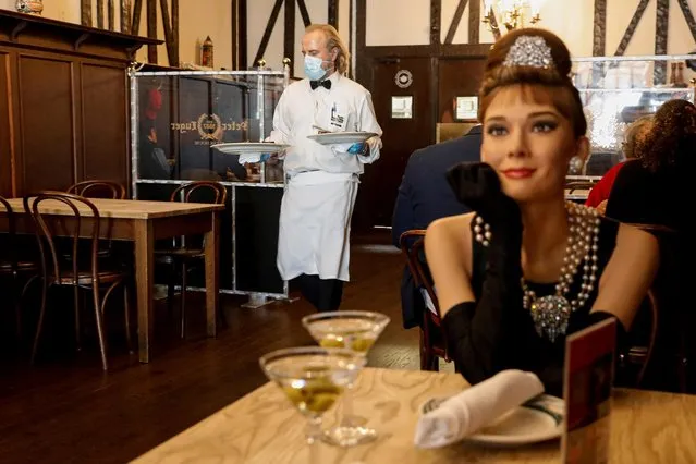 Madame Tussauds's wax figure of Audrey Hepburn sits at an empty table to comply with coronavirus disease (COVID-19) social distancing requirements in a dining room at Peter Luger Steak House in Brooklyn, New York U.S., February 26, 2021. (Photo by Brendan McDermid/Reuters)