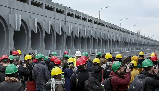 Journalists are seen near a dry spent nuclear fuel storage (ISF-2), which is under construction, at the site of the Chernobyl nuclear power plant, Ukraine, April 22, 2016. (Photo by Gleb Garanich/Reuters)