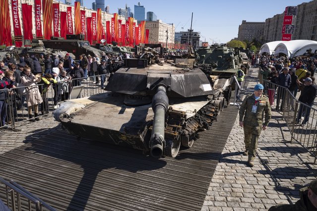 A Russian officer walks along a U.S.-made M1 Abrams tank as he prepares to speak to foreign military attaches during their visit to an exhibition of Western military equipment captured from Kyiv forces during the fighting in Ukraine, in Moscow on Friday, May 3, 2024. The exhibit organized by the Russian Defense Ministry features more than 30 pieces of Western-made heavy equipment, including a U.S.-made M1 Abrams tank and a Bradley armored fighting vehicle. (Photo by Alexander Zemlianichenko/AP Photo)