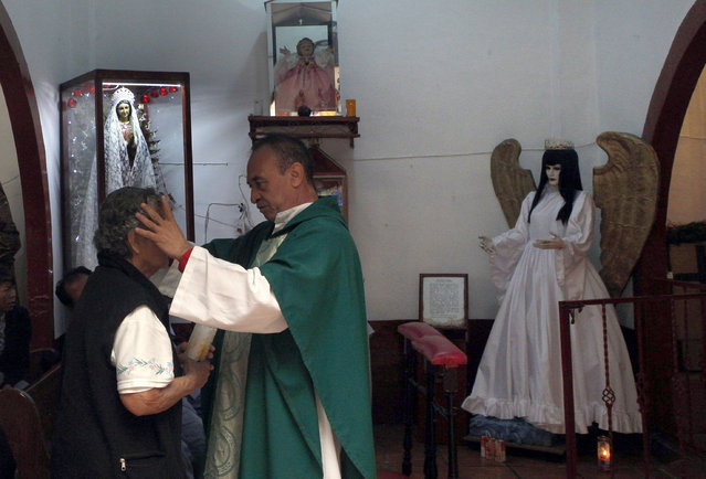 In this February 19, 2017 photo, Juan Carlos Avila blesses a devotee of the Death Saint at Mercy Church on the edge of Mexico City's Tepito neighborhood. Avila, who says he is a Catholic priest but is not listed among the archdiocese's priests, is a devotee of “La Santa Muerte” and says followers continue to grow. (Photo by Marco Ugarte/AP Photo)