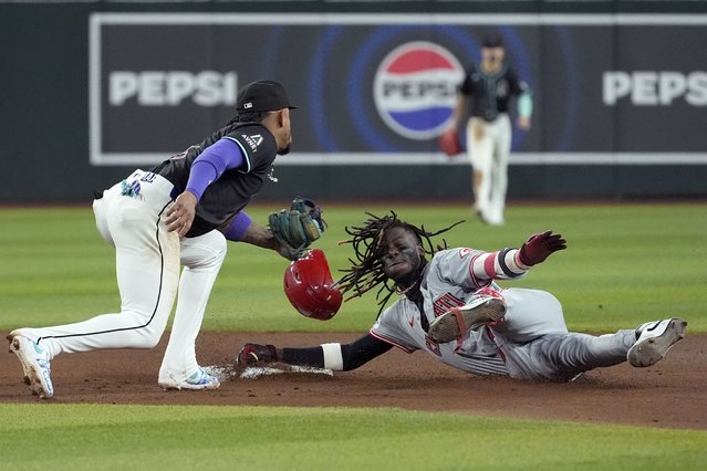 Arizona Diamondbacks second base Ketel Marte, left, tags out Cincinnati Reds shortstop Elly De La Cruz, right, at second base as De La Cruz tries to stretch a single into a double during the seventh inning of a baseball game Monday, May 13, 2024, in Phoenix. (Photo by Ross D. Franklin/AP Photo)