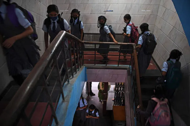 Students climb a staircase to attend their classes at a school in Mumbai on January 24, 2022, after schools were reopened that were closed as a preventive measure to curb the spread of the Covid-19 coronavirus. (Photo by Indranil Mukherjee/AFP Photo)