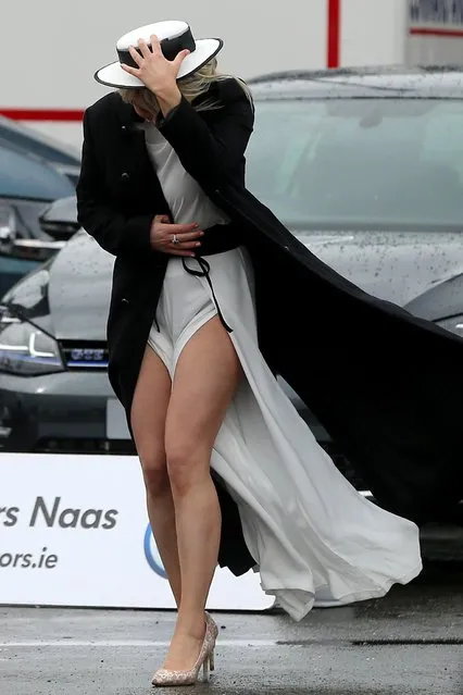 A racegoer struggles to cope with the windy conditions on arrival at the Punchestown Festival of horse racing at Punchestown, Co. Kildare, Ireland, Thursday April 28, 2016. The normal clement spring weather has taken a turn for the worst in many parts of the region. (Photo by Niall Carson/PA WIre via AP Photo)