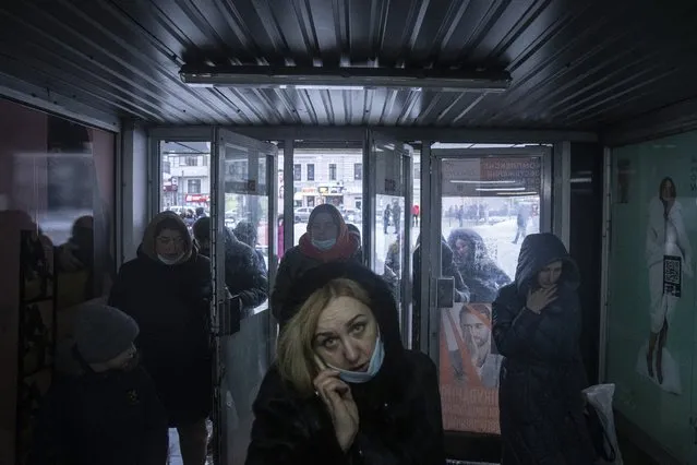 A woman speaks on the phone as she entering the subway in Kharkiv, Ukraine, Friday, January 28, 2022. (Photo by Evgeniy Maloletka/AP Photo)
