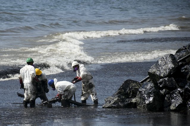 Workers from state own Heritage Petroleum Oil and Gas Company clean up an oil spill that reached Rockly Bay beach, in Scarborough, south western Tobago, Trinidad and Tobago, Sunday, February 11, 2024. (Photo by Akash Boodan/AP Photo)