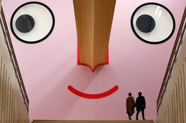 People walk at the entrance of the “Giro Giro Tondo design for children” exhibition, at the Triennale museum, in Milan, Italy, Monday, April 3, 2017. The Milan Design week is taking place in various locations across Milan from April 4 through 9, 2017. (Photo by Antonio Calanni/AP Photo)