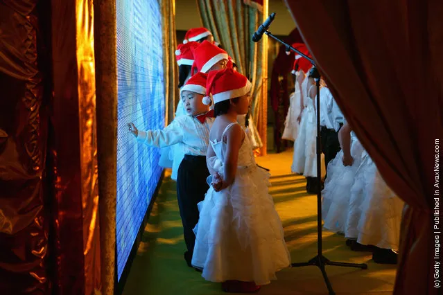 Chinese children sing Christmas songs for customers at a shopping center on Christmas Eve