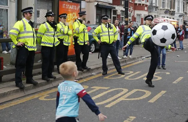 Britain Soccer Football, West Ham United vs Manchester United, Barclays Premier League, Old Trafford on May 10, 2016. Police play football with a young West Ham fan before the match. (Photo by Eddie Keogh/Reuters/Livepic)