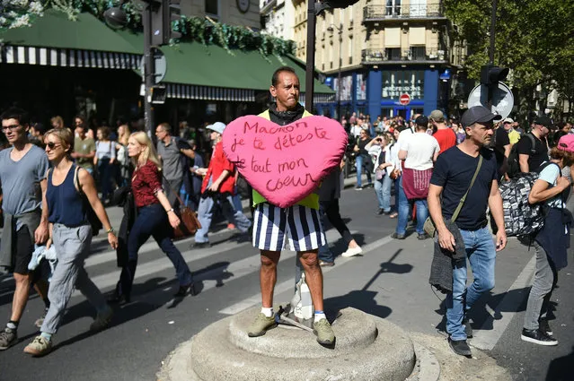 A yellow vest holds a stuffed heart reading “Macron, I hate you from all of my heart” during clashes with riot police as part of a climate change protest in Paris, on September 21, 2019. (Photo by Lucas Barioulet/AFP Photo)