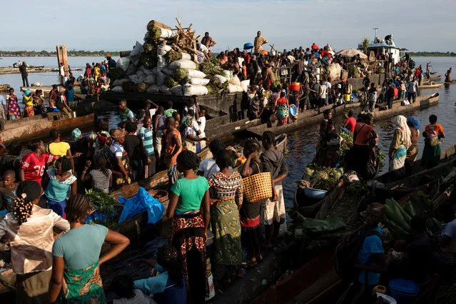 Boats filled with bushmeat arrive at Lingunda market, in Mbandaka, Democratic Republic of the Congo on October 19, 2018. Several hundred men and women wait to buy meat before selling it. (Photo by Thomas Nicolon/Reuters)