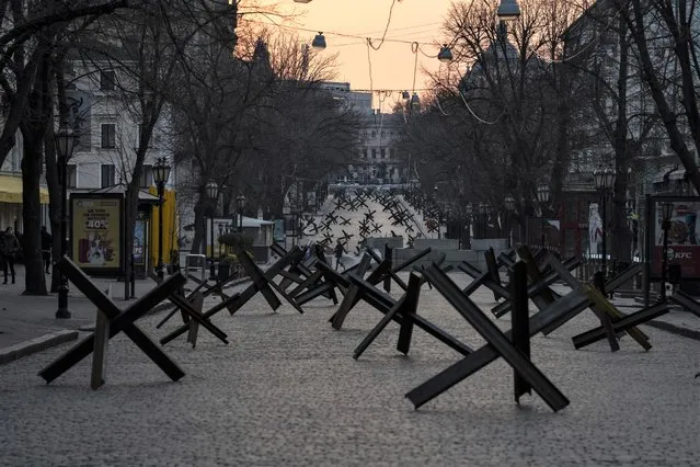 Anti- tank barricades are placed on a street as preparation for a possible Russian offensive, in Odesa, Ukraine, Thursday March 24, 2022. (Photo by Petros Giannakouris/AP Photo)