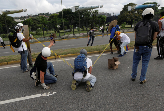 Demonstrators use a giant slingshot during a rally against Venezuela's President Nicolas Maduro in Caracas, Venezuela on May 2, 2017. (Photo by Marco Bello/Reuters)