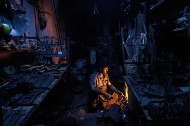 A Pakistani black smith works in his workshop in Karachi, Pakistan, Monday, April 25, 2016. (Photo by Shakil Adil/AP Photo)